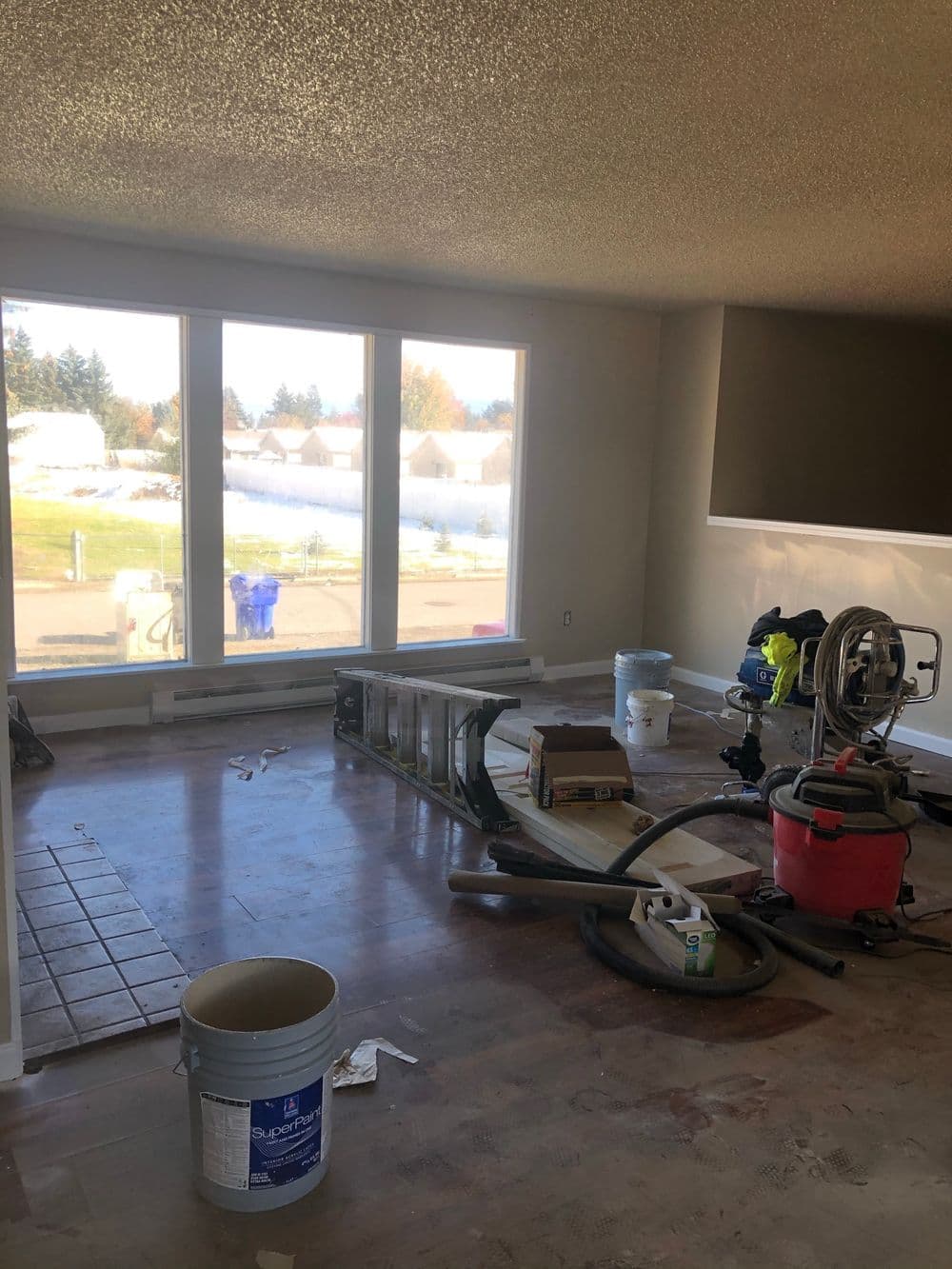 Renovation in progress with construction tools and materials in a bright, spacious room.