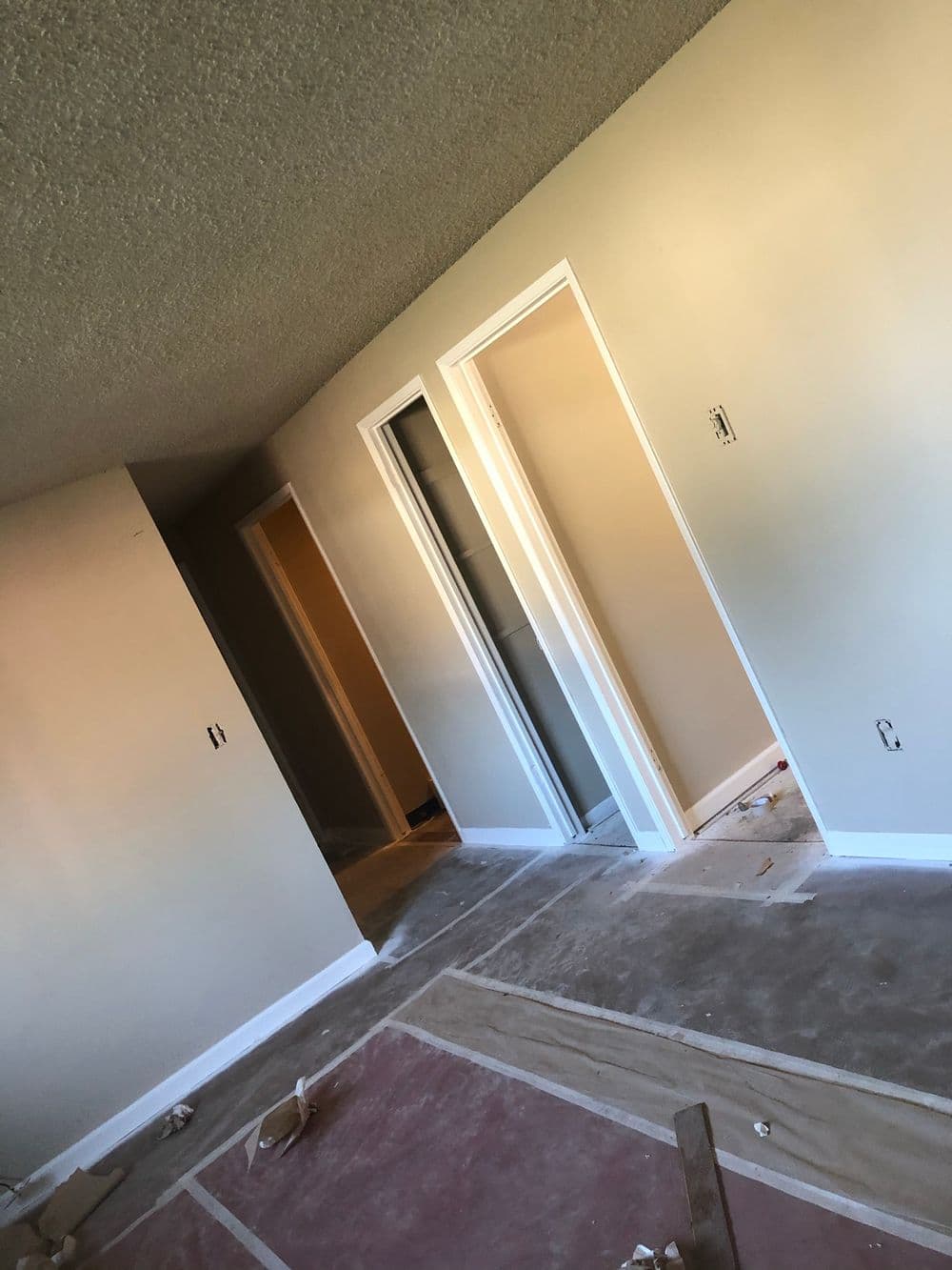 Interior of a room showing freshly painted walls and doorways under renovation.